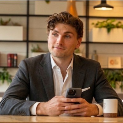 Portret van Luuk van de Ven aan een tafel met een telefoon